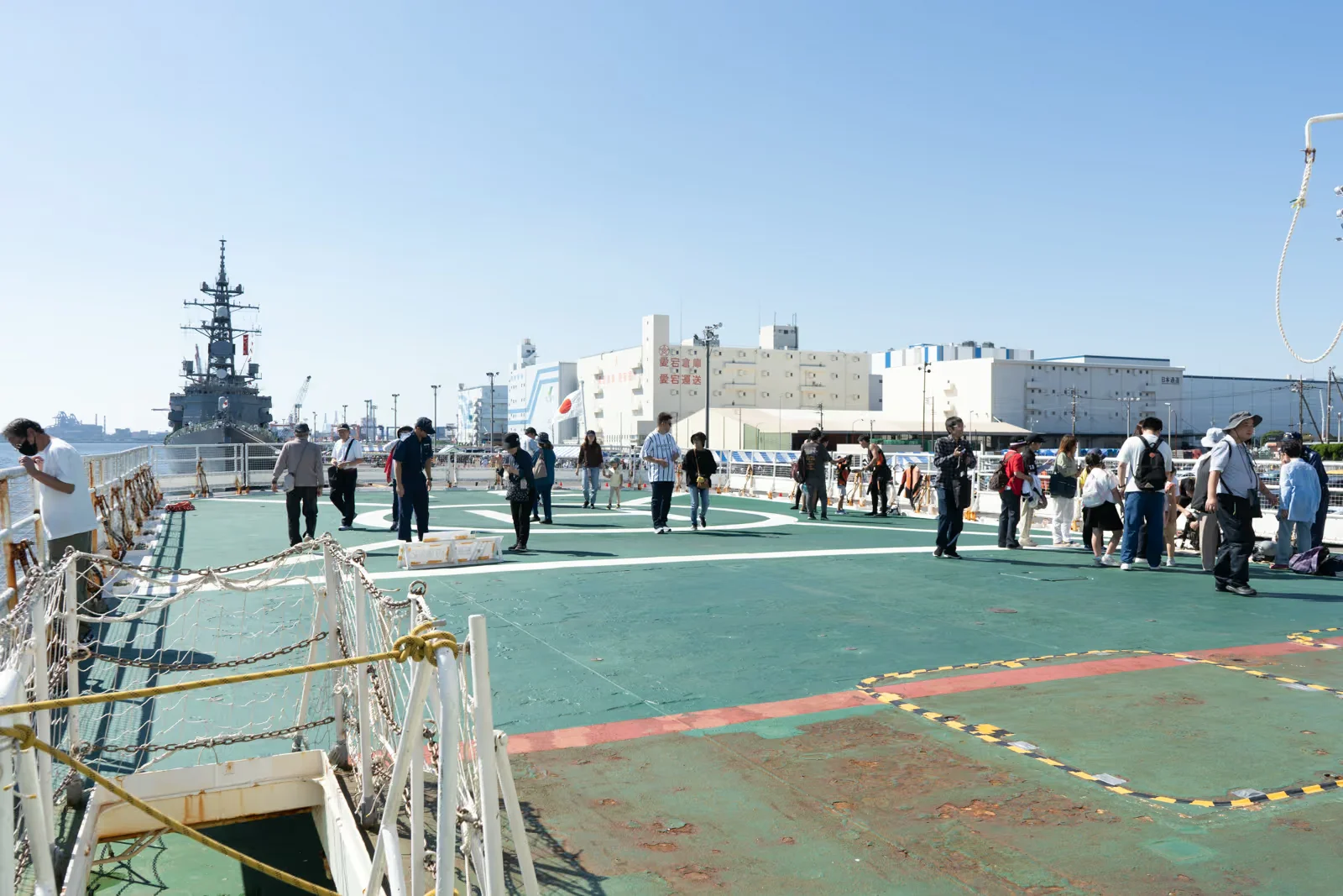 巡視船いずの後部甲板と見学者、奥に停泊する護衛艦ゆうだち