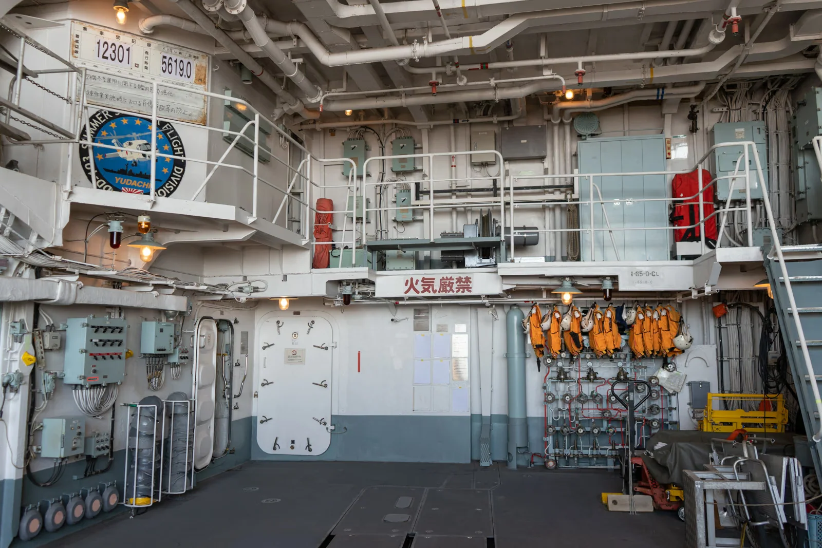 護衛艦ゆうだちの格納庫に並ぶ救命胴衣や各種装備