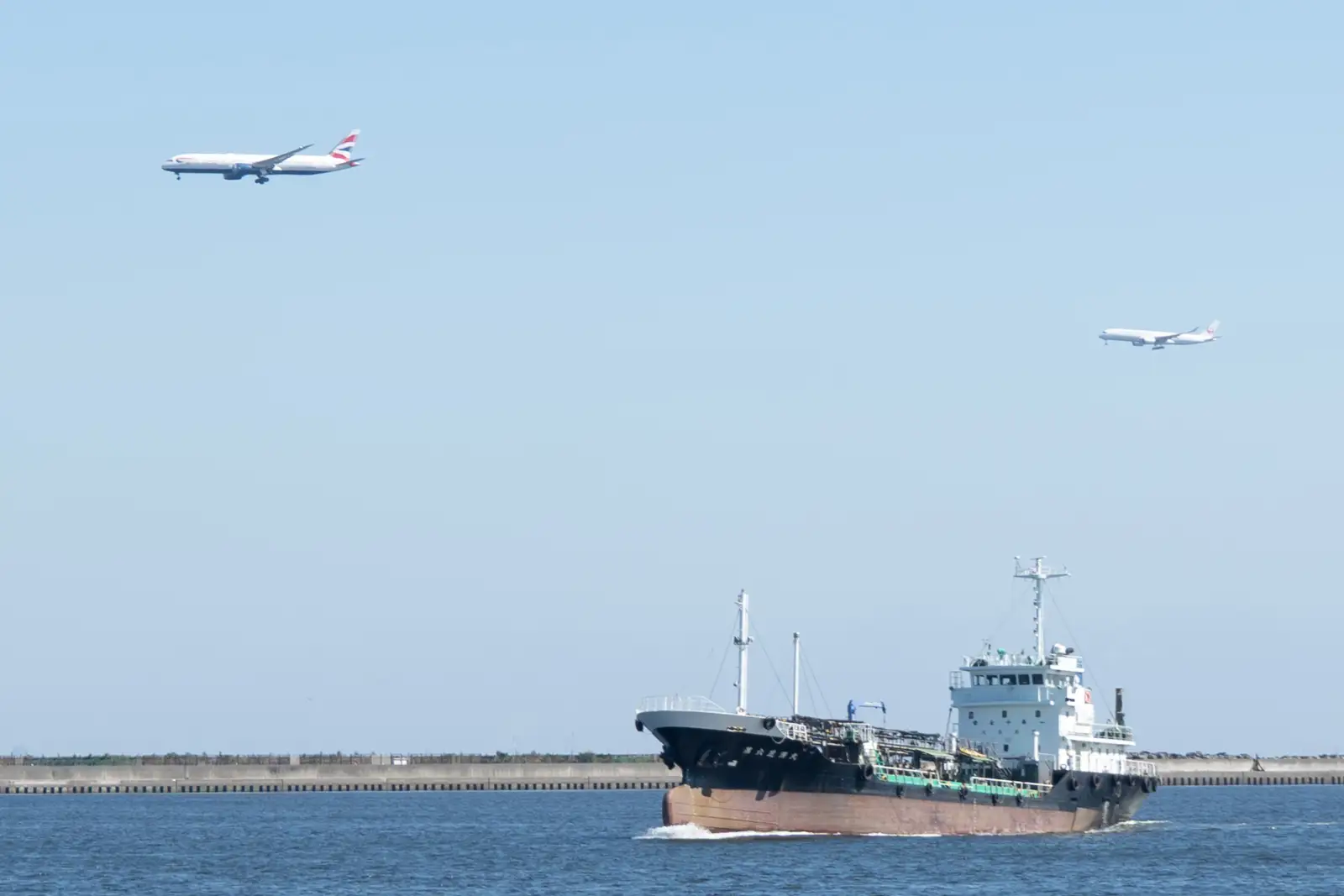 東扇島東公園から見た羽田空港へ向かう2機の飛行機と京浜運河を航行する船